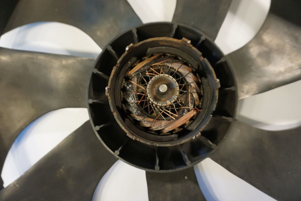 Außenläufermotor, ... Sonder Aufbau ... hier ein Ausreißer - nämlich einer (ungewöhnlich) mit Anker, ein Kollektormotor und dazu mit Permanentmagneten bestückt, im Bild ist der offene E Motor mit Blick in die Nabe zu sehen, typisch die Axialschaufeln des Ventilators mit den Permanentmagneten unter der Hülle (Stator rotierend Prinzip).