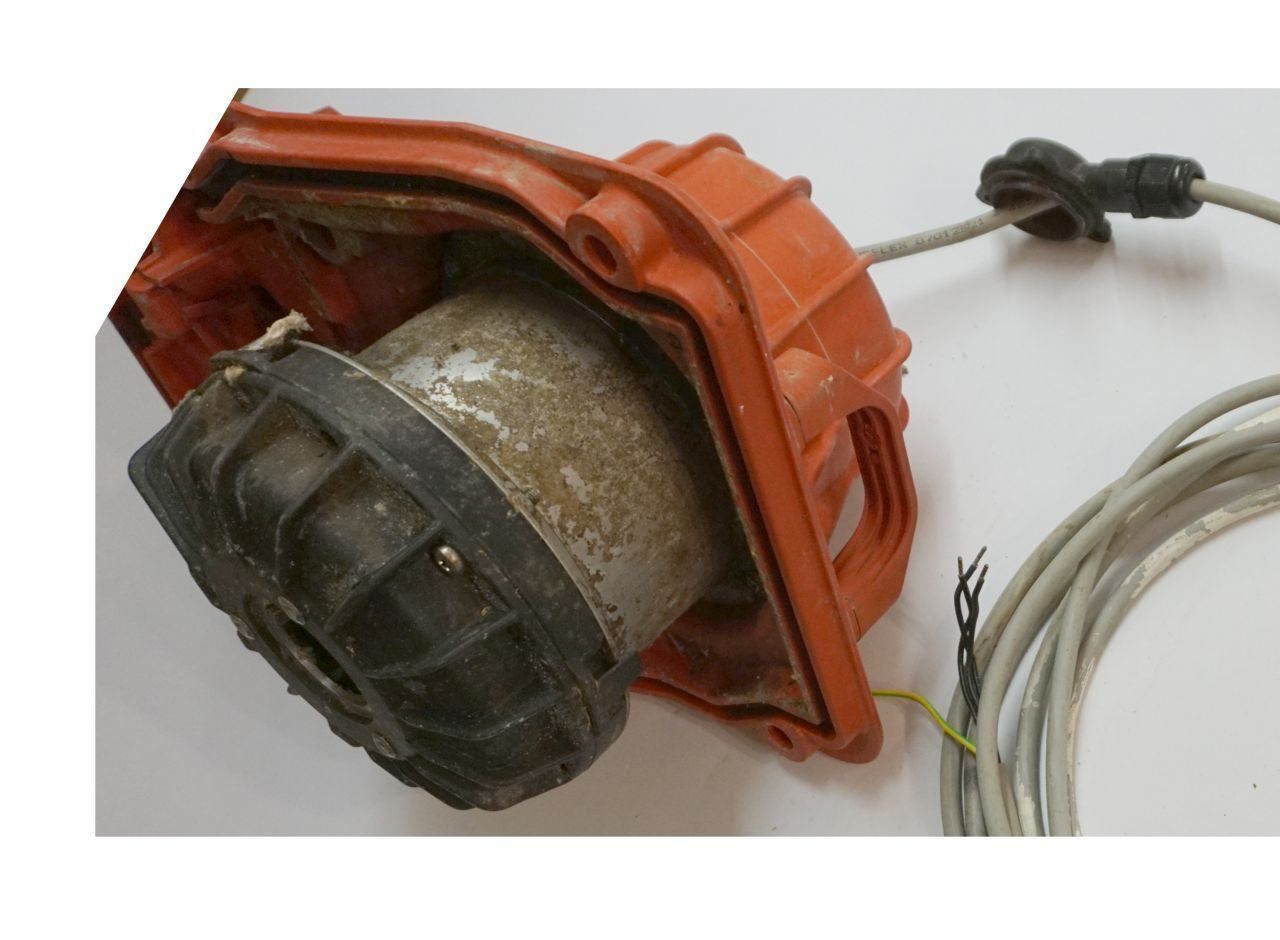 Elektromotor in Hebeanlagen D Mot Drehstrommotor Pumpenmotor Hebeanlage neu wickeln neu lagern, im Bild der Pumpenkopf mit Elektromotor in einer orangenen Kunststoffhülle mit Hebegriffen für ein und Aus Bau